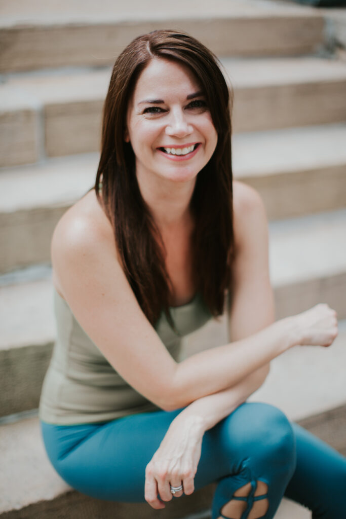 A woman sitting on some steps smiling for the camera.