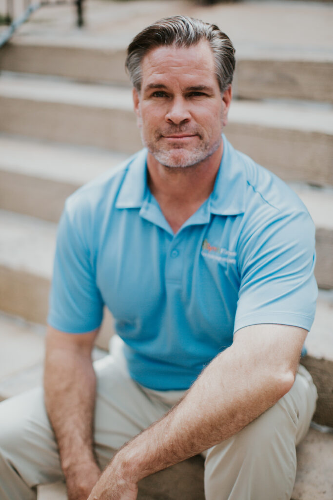 A man sitting on some steps wearing a blue shirt